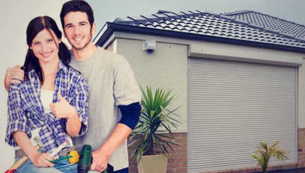 A couple who just finished installing roller shutters on their home